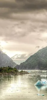 Misty mountain landscape with icy river and green valleys.