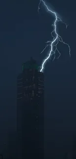 Dramatic lightning strikes a dark skyscraper at night.