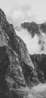 Dramatic black and white mountain ridge shrouded in clouds for mobile wallpaper.