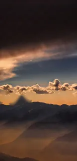 Dramatic sunset over misty mountains with vivid clouds.