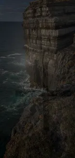 Dark rocky cliff overlooking an ocean.