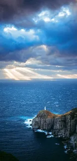 Dramatic seascape with lighthouse under cloudy sky and sunlight rays.