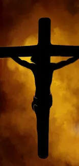 Silhouette of crucifix against fiery cloud background.