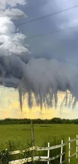 Dramatic scene of stormy clouds over green landscape.