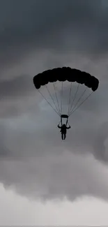 Skydiver silhouette against stormy clouds wallpaper.