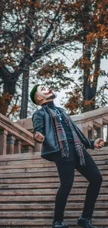 Person dramatically posing on stairs with autumn leaves.