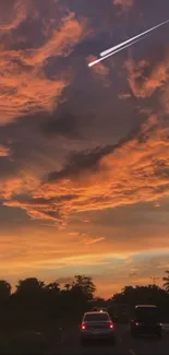 Dramatic sunset with orange clouds and a meteor streaking across the sky.