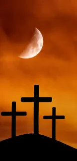 Silhouettes of three crosses under a dramatic orange sunset sky.