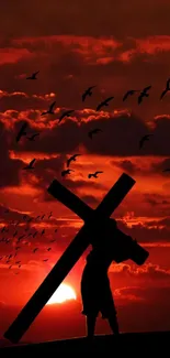 Silhouette carrying cross at vibrant sunset.