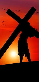 Silhouette carrying a cross against a vivid sunset backdrop with birds flying.