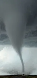 Majestic tornado forming under a stormy gray sky.