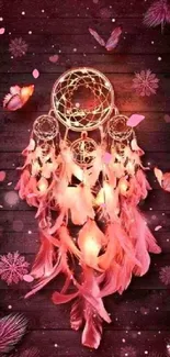 Dreamcatcher with pink feathers on a wooden background.