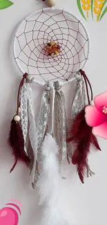 Dreamcatcher with flowers and feathers on white.