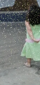 Child in a green dress walking amid golden star sprinkles.