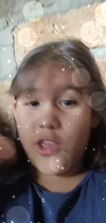 Child surrounded by magical sparkles with a brown brick background.