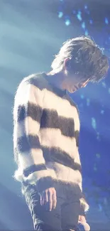 Softly lit concert scene with a performer in a striped sweater.