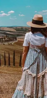 Woman in a summer dress overlooking a Tuscan landscape.