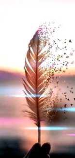 Artistic wallpaper of a dissolving feather against a peach sunset background.