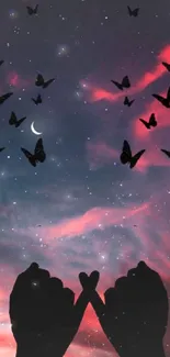 Silhouette of hands and butterflies under a starry, colorful night sky.