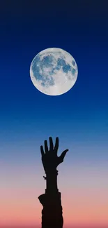 Hand reaching up to a full moon in a vibrant night sky.