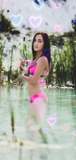 Woman in pink bikini standing in a lake with heart overlays.