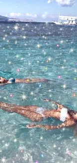 Two women float in a shimmering blue sea under a clear sky.