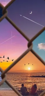 Dreamy beach sunset with fence silhouette, birds, and vibrant sky hues.