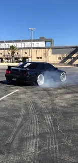 Black sports car drifting on sunny day in empty parking lot.