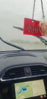 Rainy drive view from car interior with wipers and maps.