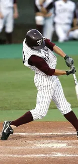 Baseball player swinging on the field with teammates in the background.