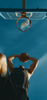 Basketball player performing a dunk under a blue sky.