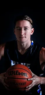 Dynamic basketball player with ball in intense pose, dark background.