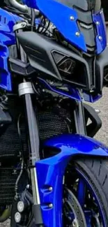 Close-up of a sleek blue motorcycle showcasing its dynamic front design.