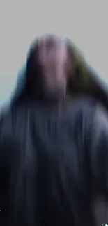 Dynamic blurred figure against gray background, creating motion.