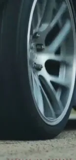 Close-up of a dynamic car wheel in motion on a mobile wallpaper.