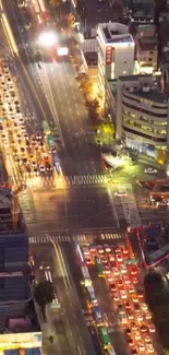 Aerial night view of a bustling city intersection with vibrant lights.