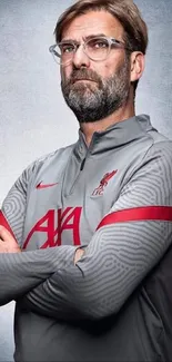 Portrait of a coach in grey with red accents, arms crossed.