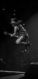 Black and white image of a guitarist jumping on stage during a concert.