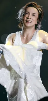 Energetic performer in white during concert.