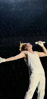 Performer passionately sings on stage in the rain during a live concert.