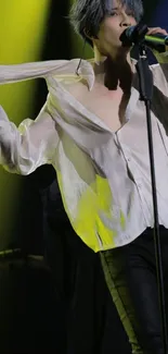 Performer on stage with microphone under colorful lighting.