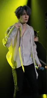 Dynamic stage performer in vibrant yellow lighting captured during a live concert.