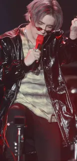 Dynamic performer in black leather jacket with vibrant stage lighting.