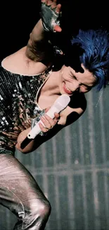 Dynamic performer with blue hair and sequined top on stage.