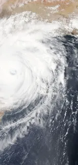 Dynamic cyclone storm with swirling clouds viewed from above.