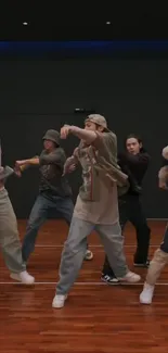 Energetic dance crew performing in casual attire on a wooden stage.