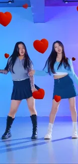 Two women dancing with heart decorations on a blue background.