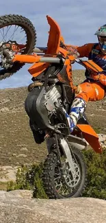 Dirt bike performing a stunt on rocky terrain with scenic background.