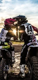 Two dirt bike riders at sunset on a track.