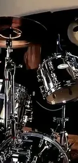 Silver drum set on stage with dark background.